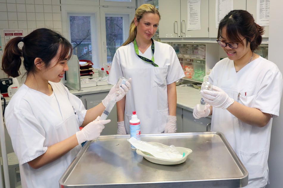 Vietnamesische Pflegekräfte in der Ausbildung, werden bei ihrer Arbeit in der Onkologie von der leitenden Gesundheits- und Krankenpflegerin begleitet.