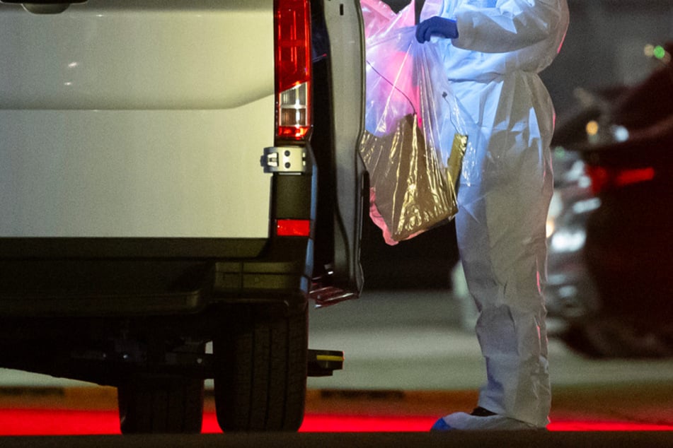 Ein Kriminaltechniker bringt einen Plastikbeutel zum Wagen. Bei einer Explosion in einem Verwaltungsgebäude von Lidl sind am Mittwoch drei Personen verletzt worden.