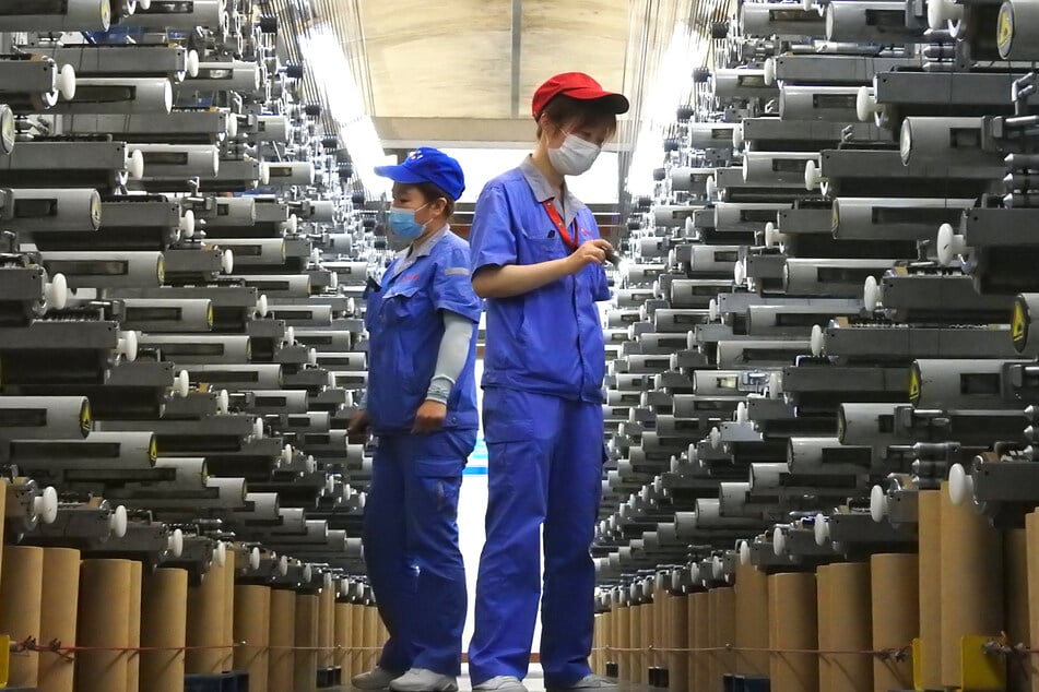 Arbeiter überprüfen eine Produktionslinie im Lianyungang Economic and Technological Development Area in Lianyungang in der ostchinesischen Provinz Jiangsu.