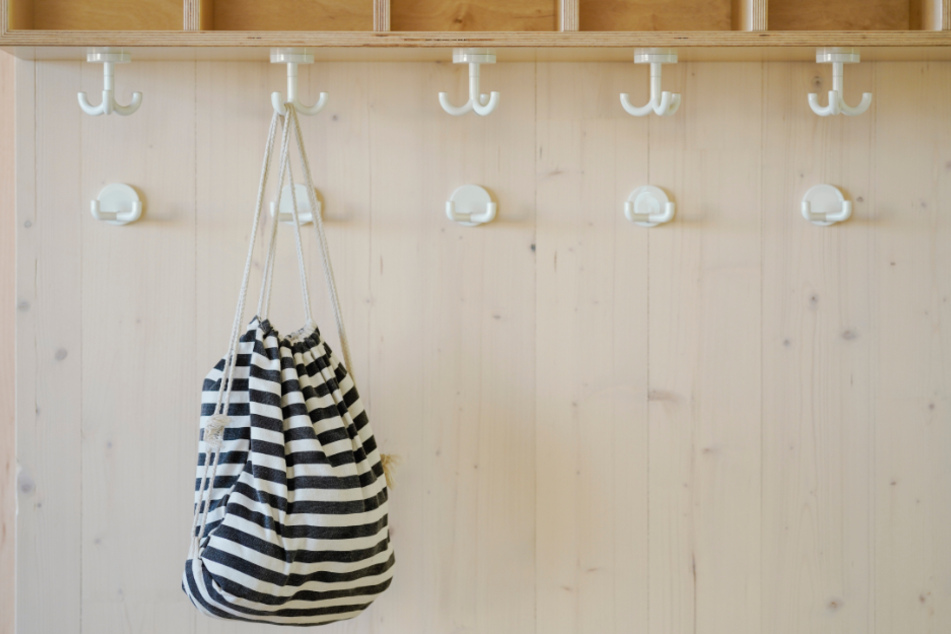 Alle schon ausgeflogen: Bis auf den Turnbeutel eines Kindes ist die Garderobe der Kita leer. (Symbolbild)