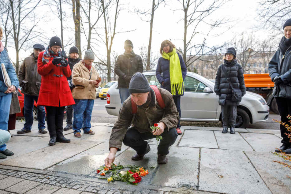 Matthias Krause (67, aus Weimar) legt eine Rose nieder.