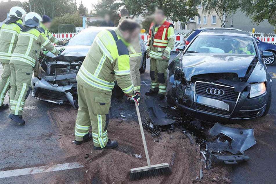 Feuerwehrleute beseitigen auf der Kreuzung Radeburger Straße/Ludwig-Kossuth-Straße ausgetretene Betriebsstoffe.