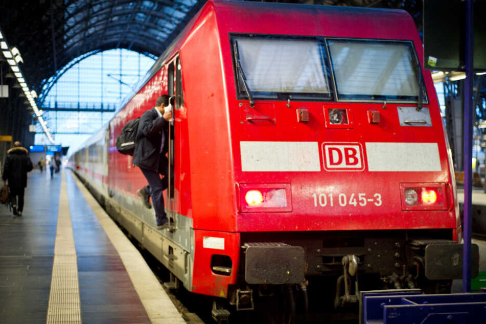Ein Zug steht abfahrbereit in einem Bahnhof. Auf den Puffern (vorne) der Lok sind zwei Jugendliche gesurft (Symbolbild).