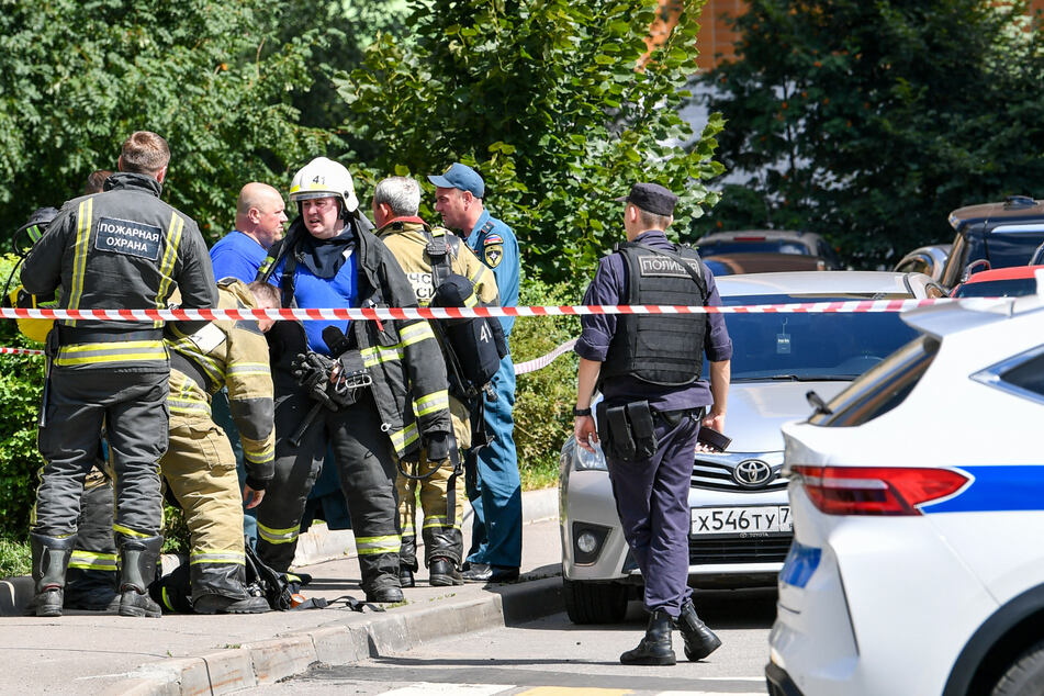 Sicherheitskräfte sammeln sich in der Nähe des Tatorts einer Explosion in einem Wohngebiet.