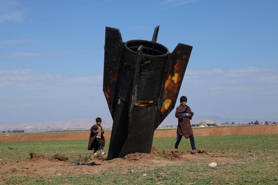 Kinder spielen an einer iranischen Rakete, die am Flughafen Al-Qamishli in Syrien abstürzte.