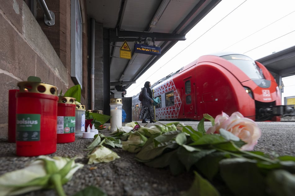 Kerzen und Blumen erinnern auf dem Bahnsteig am Bahnhof in Landstuhl an den getöteten Bahnmitarbeiter Serkan C. Er wurde am 2. Februar von einem Schwarzfahrer angegriffen und starb später im Krankenhaus. (Archivbild)