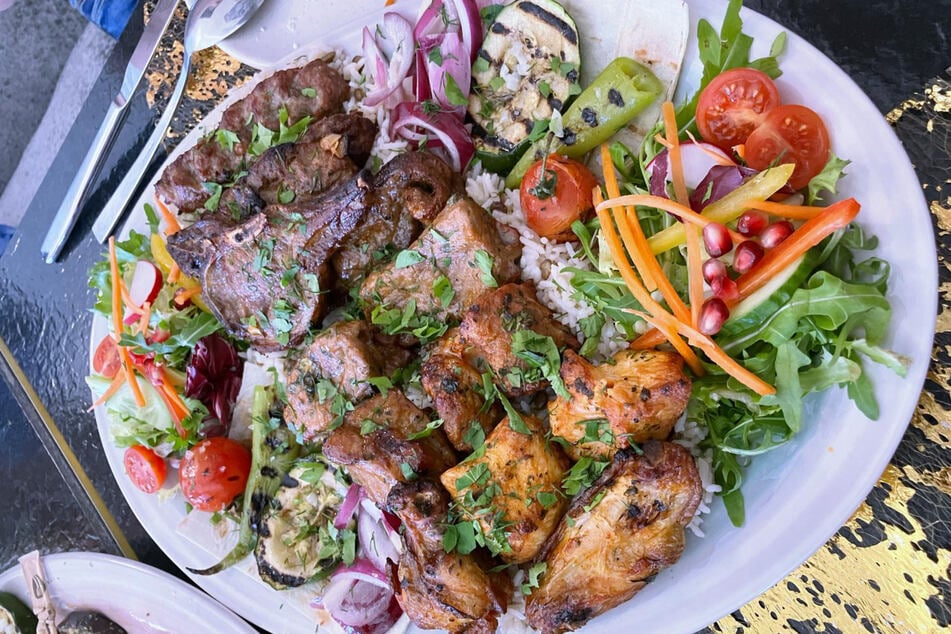 Genuss pur: Lamm, Kalb, Hähnchen auf Reis mit gegrilltem Gemüse und frischem Salat.