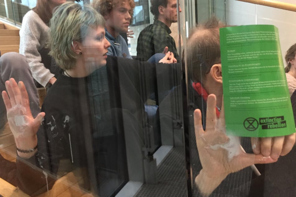 Demonstranten besetzen eine Treppe im Landtag.