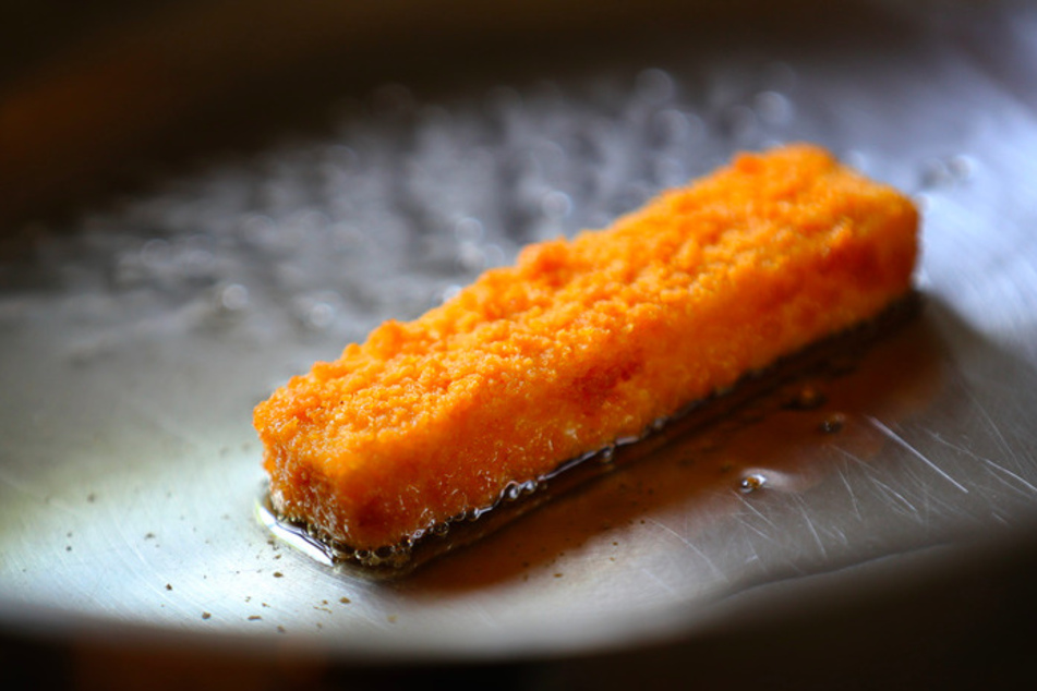 Ein Fischstäbchen in einer Pfanne. (Symbolbild)