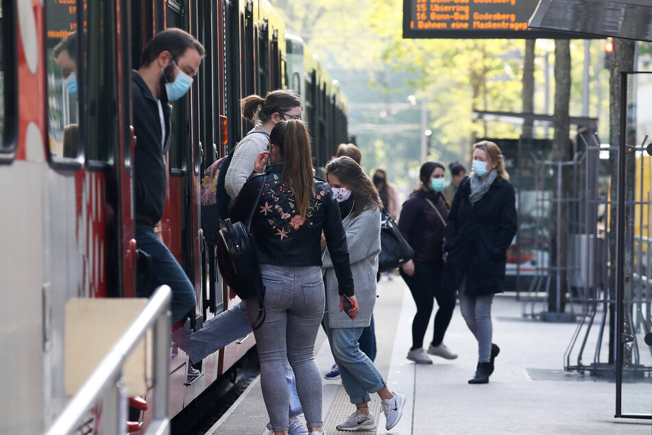 Fahrgäste steigen mit Mundschutz aus und in eine Stadtbahn am Neumarkt (Archivbild).