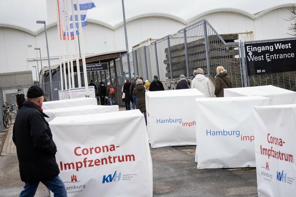 Menschen stehen vor dem Corona-Impfzentrum an den Hamburger Messehallen.