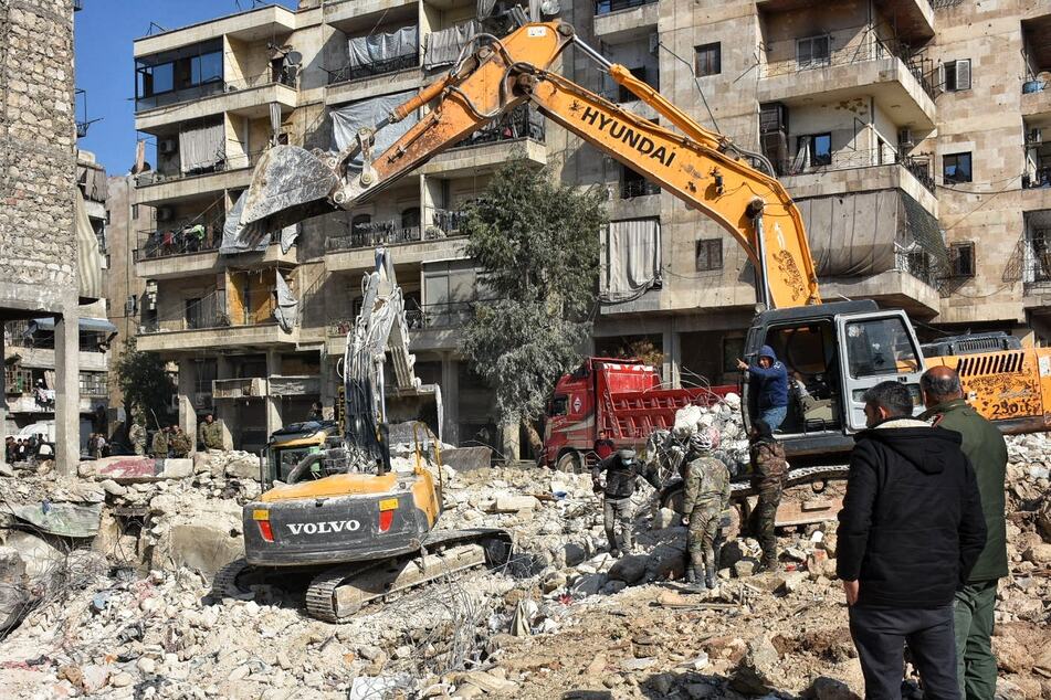 Rettungskräfte und Freiwillige suchen nach Überlebenden in den Trümmern eines Gebäudes, das bei dem tödlichen Erdbeben an der türkisch-syrischen Grenze eingestürzt war.