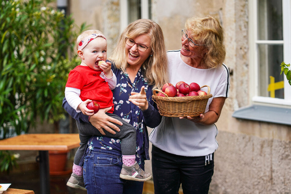 Jade Kay (25) mit Sonja (1) und Oma Anja (54). Die kleine Sonja ist die Enkelin von Udo Jentzsch, Chef des Landesverbands Sächsisches Obst. Alle drei schwören auf die neue Apfelsorte "Kanzi" - am liebsten frisch zum Abbeißen.