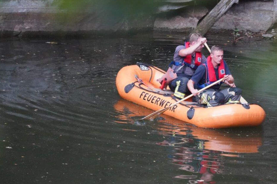 Mit einem Boot sind Feuerwehrleute auf dem Gewässer unterwegs.