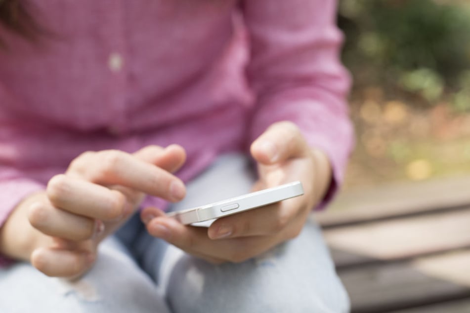 Ein Kind hält ein Smartphone in der Hand. (Symbolbild)