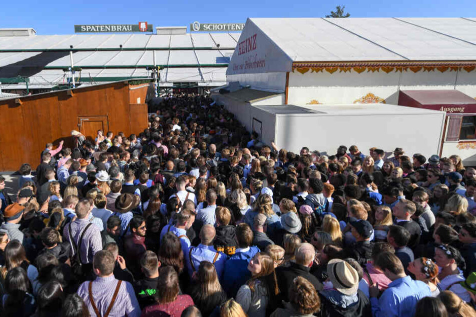 Besucher drängen sich am Eingang eines Festzeltes und warten auf Einlass.