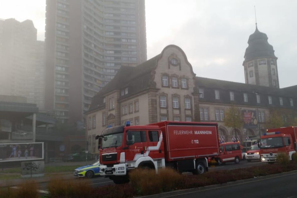 Feuerwehrfahrzeuge vor dem rauchenden Hochhaus.