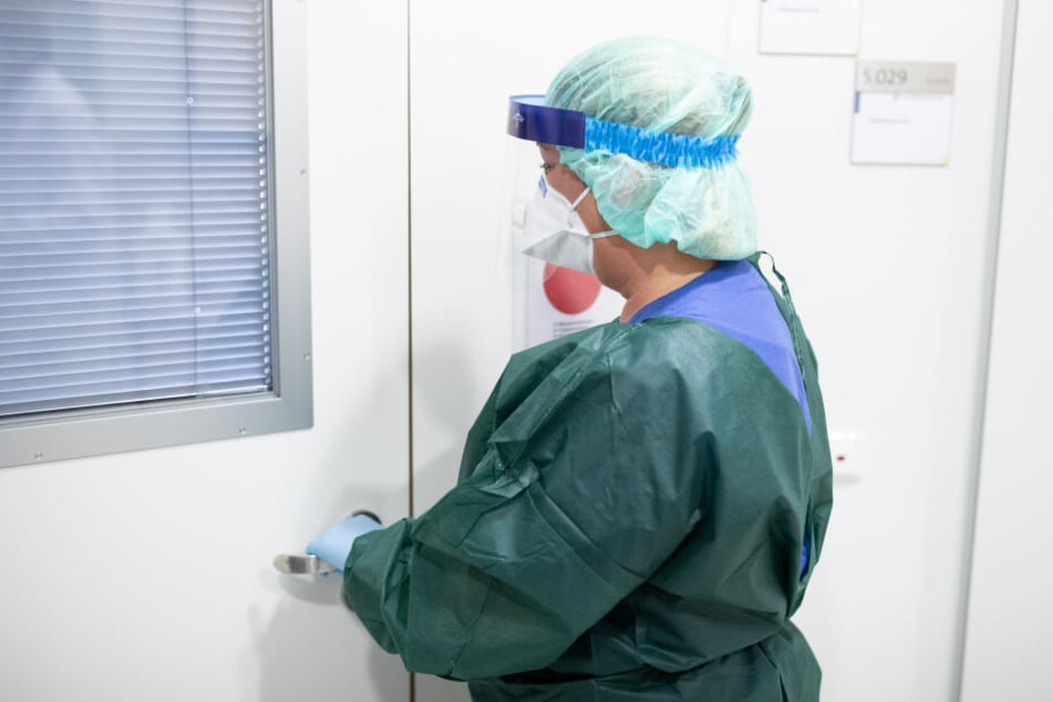 Eine Frau in einem Krankenhaus in Schutzkleidung. (Symbolbild)