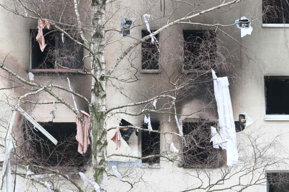Eine Birke gegenüber des Plattenbaus hängt nach der Explosion voller Kleidungsstücke. Auch ein Fensterrahmen ist unten links zu erkennen.