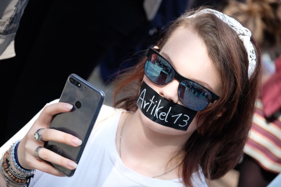 Teilnehmer einer Demonstration unter dem Motto „Save the Internet“ versammeln sich mit Schildern in Jena.