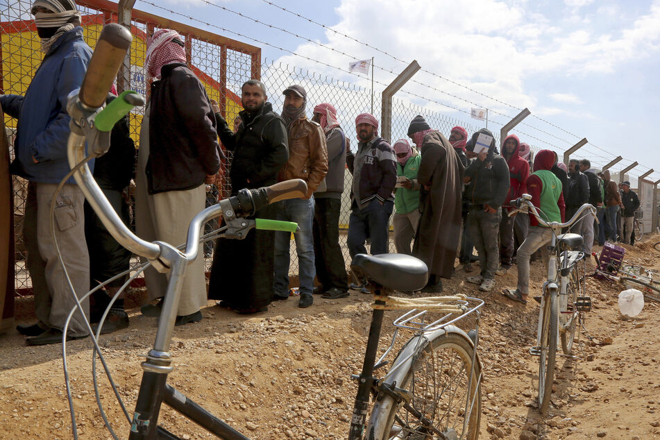 Syrische Flüchtlinge stehen in einer Schlange im Azraq-Flüchtlingslager.
