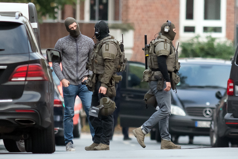 Einsatzkräfte unterhalten sich nach einer beendeten Geiselnahme.