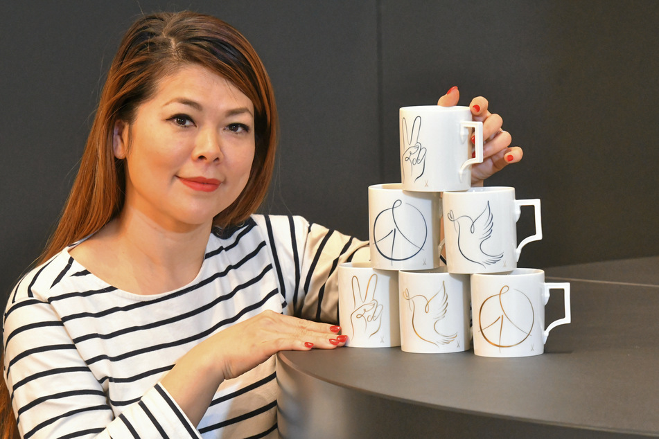 Manufaktur-Mitarbeiterin Peihsuan Hering (42) zeigt die Kaffeebecher mit drei verschiedenen Friedenssymbolen.