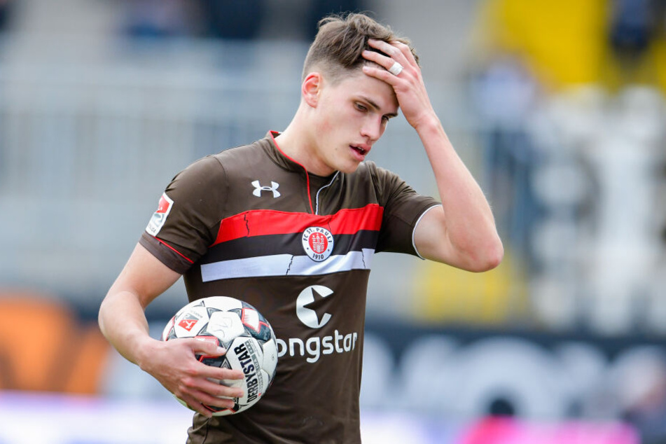 St. Paulis Luca Zander steht mit dem Spielball auf dem Spielfeld im Hardtwaldstadion.
