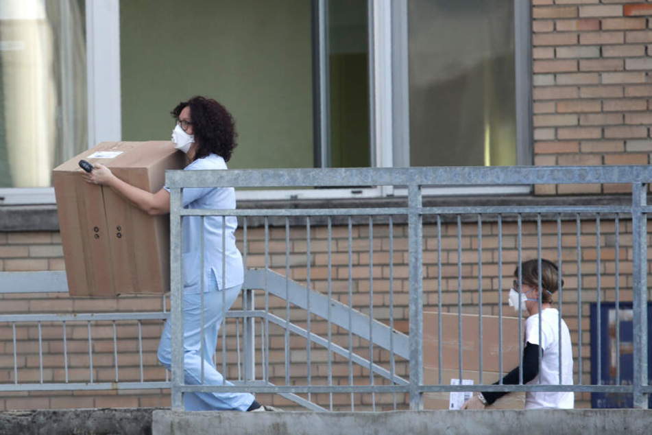 Mitarbeiter des Codogno Krankenhauses tragen Kisten in das Krankenhaus.