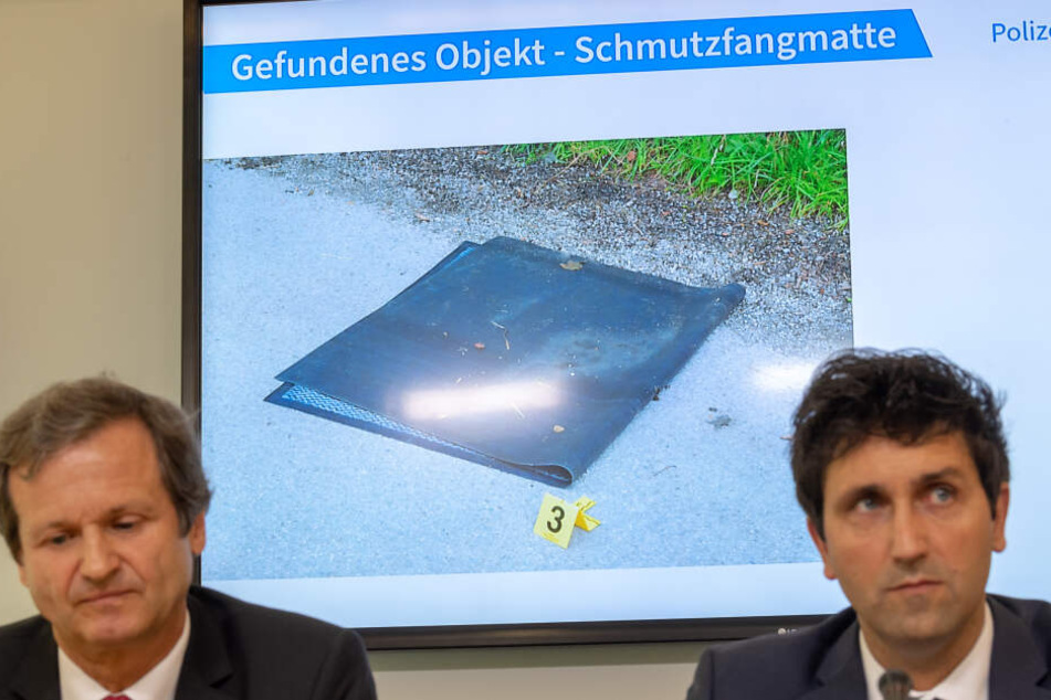 Ken Heidenreich (l), Staatsanwaltschaft München 1 und Josef Wimmer, Leiter Kommissariat 11 zeigen das Beweisstück Fußmatte.