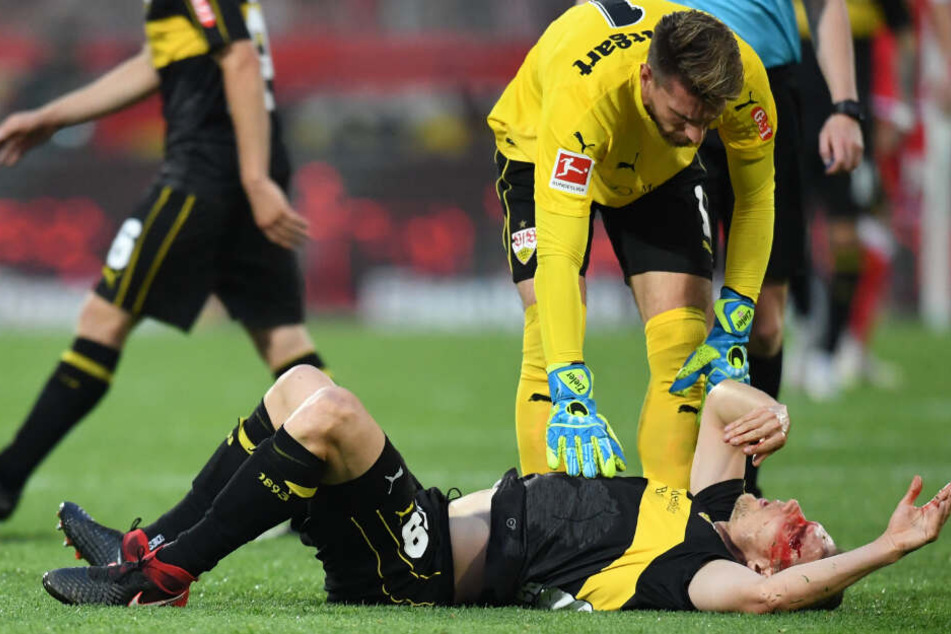 Holger Badstuber liegt nach Zusammenstoß auf dem Boden, Torwart Ron-Robert Zieler beugt sich über ihn.