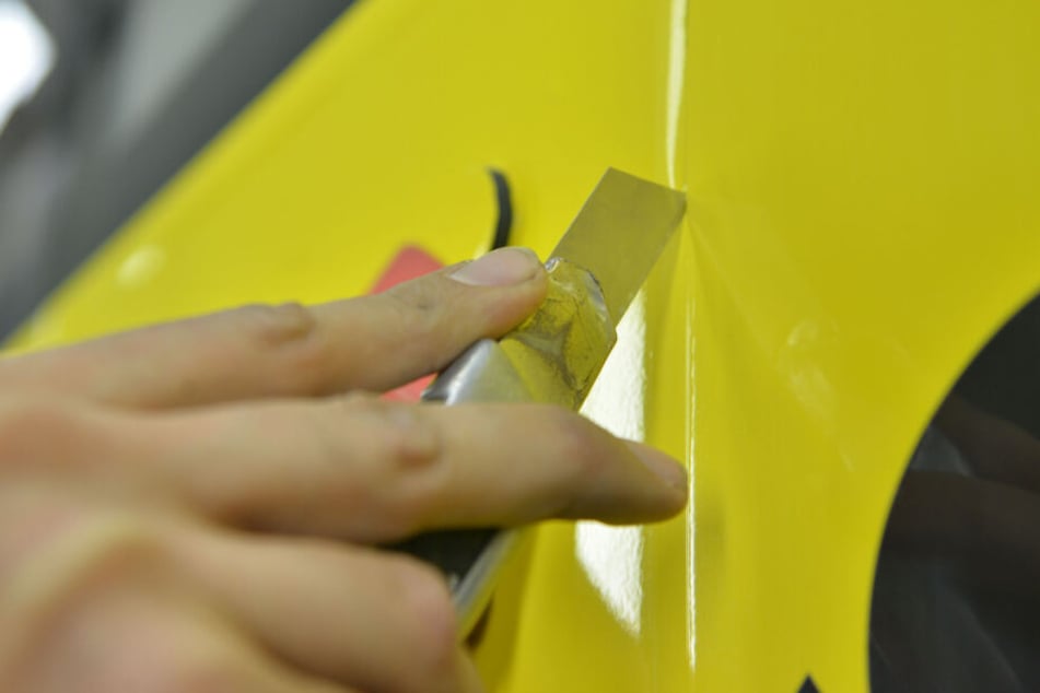 Sauberer Schnitt, saubere Werbung: Damit die Klebefolie optimal aufgetragen werden kann, muss sie zurechtgeschnitten werden - auch um Luftbläschen zu verhindern.