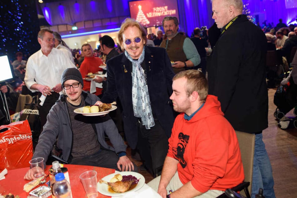 Musiker Frank Zander (M) verteilt bei seinem 25. Weihnachtsfest für Obdachlose und Bedürftige Weihnachtsgans an die Gäste.