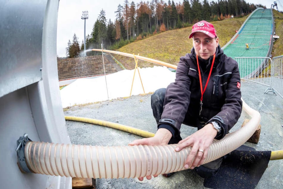 Techniker Markus Reinert (42) kontrolliert den Schlauch eines Containern, in dem künstlicher Schnee produziert wird - quasi zum "Zufüttern".