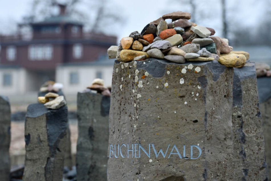 Kleine Steine liegen im ehemaligen Konzentrationslager Buchenwald auf einem Gedenkstein mit der Aufschrift "Buchenwald".