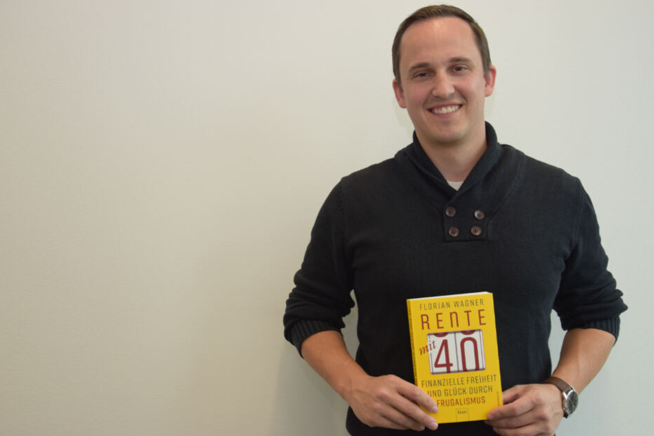 Florian Wagner hält sein Buch "Rente mit 40" in den Händen.