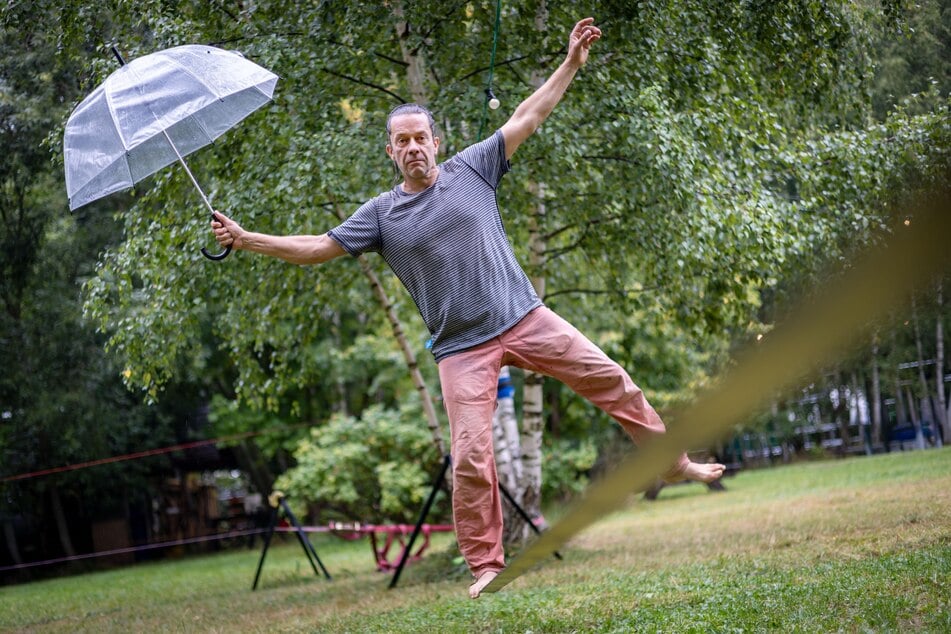 Sportler Jörg Schaarschmidt (48) wagte sich am Freitag trotz Regen mit Schirm auf die Slackline.