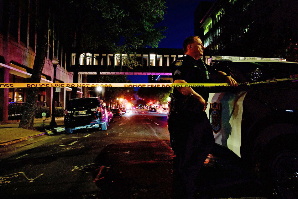 Police officer David Bell stands watch at the scene of a mass shooting in downtown Sacramento, California.