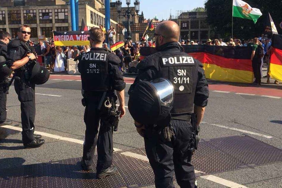 Polizisten stehen bei der PEGIDA- und AfD-Demo vor dem Landtag während des Merkel-Besuchs.