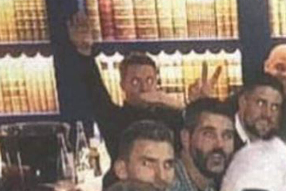 Auf dem Foto hebt der 32-Jährige die rechte Hand, während er die linke Hand über den Mund hält.