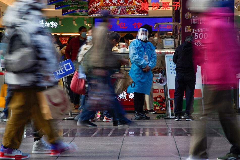 People walk down the street in Shanghai, which has also been hit by a wave of Covid infections.