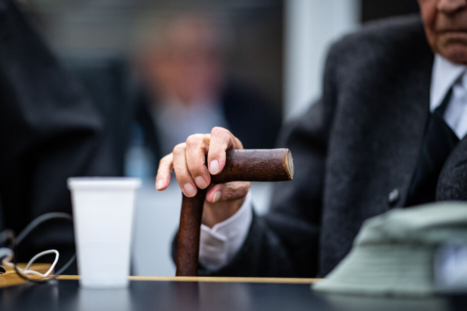 Zu Beginn des Prozesses gegen einen ehemaligen SS-Mann sitzt der Angeklagte im Landgericht auf der Anklagebank und hält mit seiner Hand seinen Gehstock fest. Das Landgericht Münster hat das Verfahren gegen einen ehemaligen SS-Wachmann im Konzentrationslag