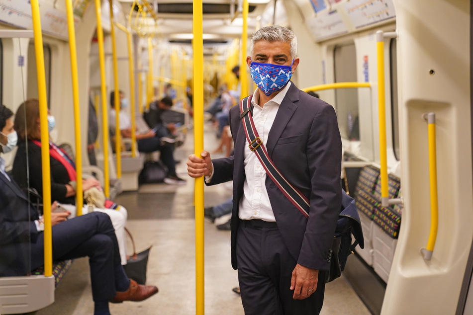 Großbritannien, London: Sadiq Khan, Bürgermeister von London, trägt eine Mund-Nasen-Bedeckung, während er mit der U-Bahn zu seinem Besuch im Londoner Transport Museum fährt.