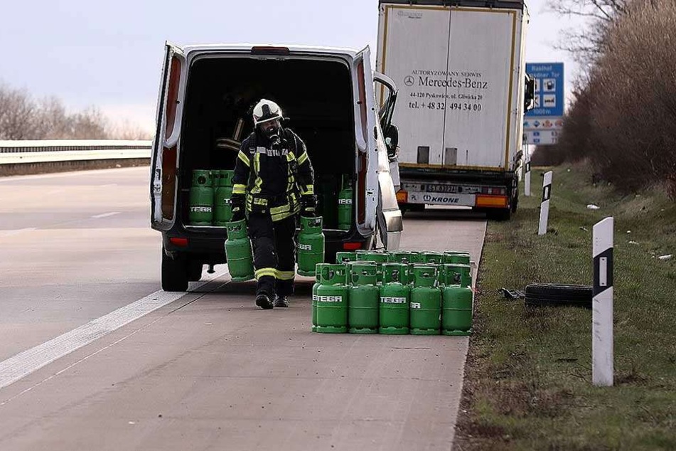 Ein Feuerwehrmann lädt die Gasflaschen aus dem verunglückten Transporter.