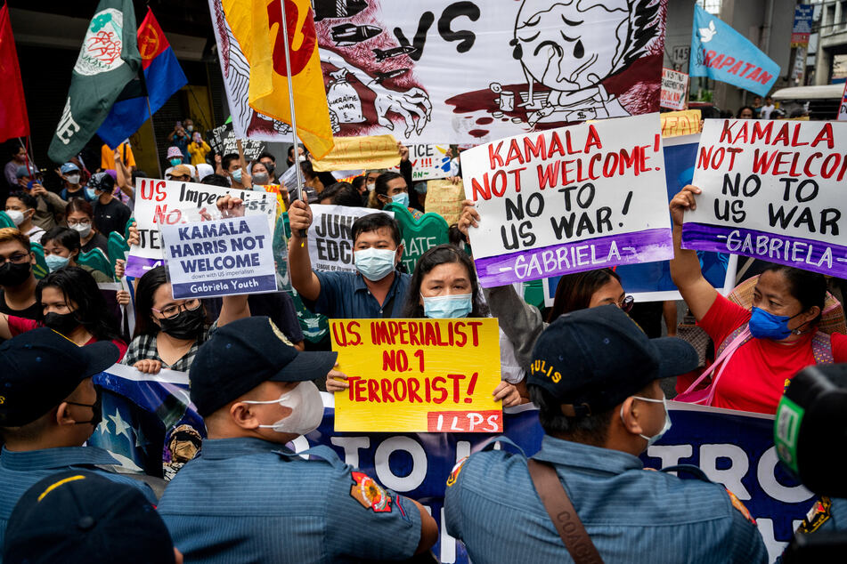 Filipino protesters in Manila hold signs during a protest against US Vice President Kamala Harris' visit to the Philippines.
