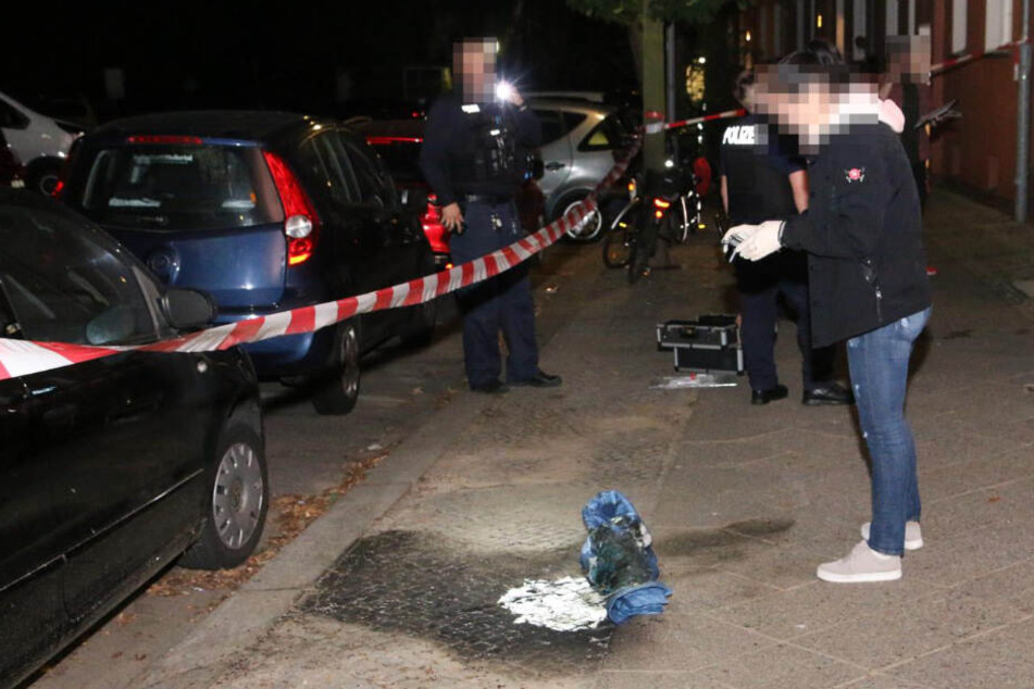 Eine Ermittlern fotografiert die verbrannte Kleidung.