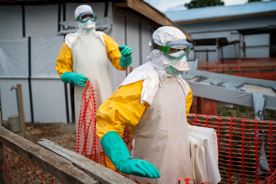 Helfer kommen in Schutzanzügen zu ihrer Schicht in einem Behandlungszentrum mit Ebola-Erkrankten.