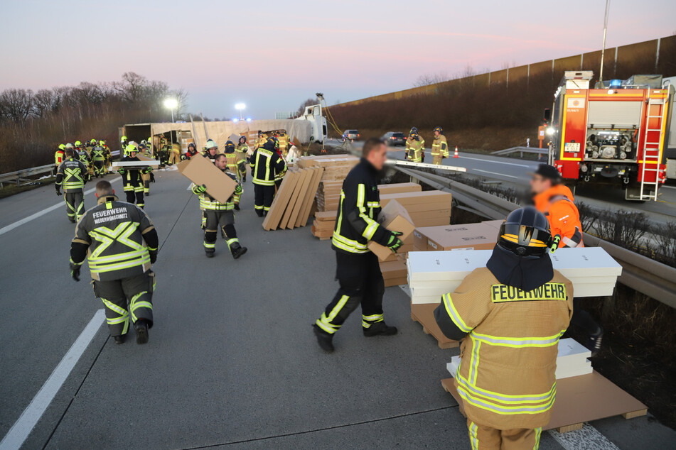 Vor der Bergung des Lkw müssen die Einsatzkräfte der Feuerwehr die Möbelkartons entladen.