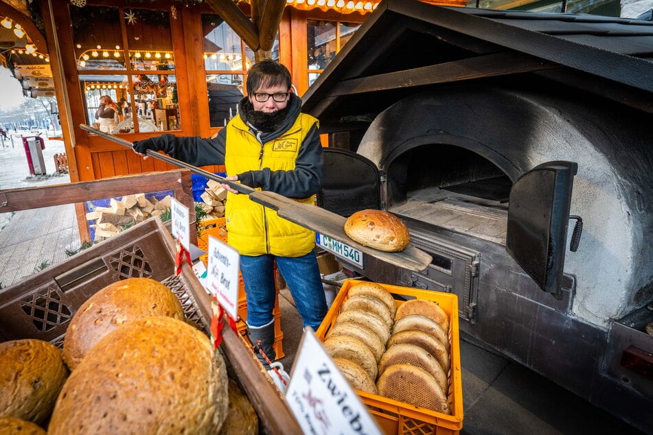 Yvonne Schreiter (37) von der Bäckerei Meyer holt Walnussbrot aus dem Holzofen auf dem Weihnachtsmarkt.