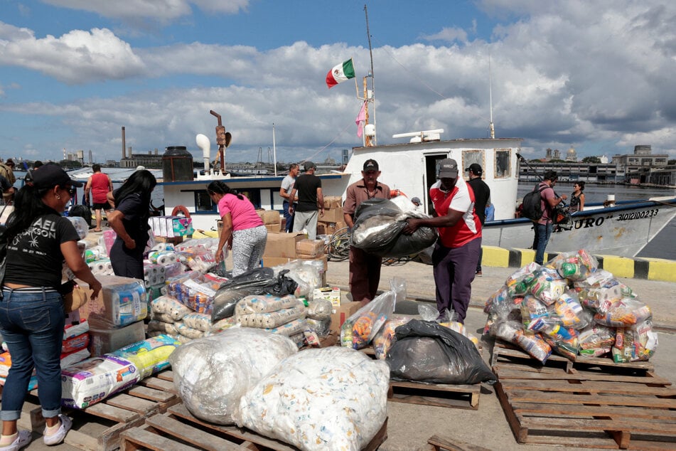 Activists of the Nuestra América Convoy and Cuban officials unload humanitarian aid from the vessel Maguro at Havana port.